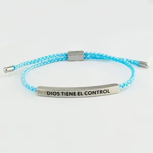 Vista di dettaglio della barra in acciaio, bracciale in corda intrecciata blu con scritta.