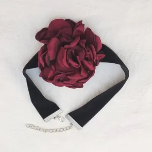 Collana girocollo in velluto nero con grande fiore di rosa in tessuto rosso scuro.