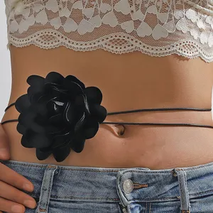 Primo piano dettagliato di un'elegante catena da vita con fiore di camelia in tessuto nero.