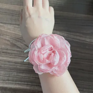 Vista ravvicinata e dettagliata dell'accessorio floreale in tessuto rosa camelia fatto a mano.