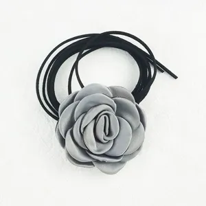Vista dettagliata della collana girocollo con fiore di camelia in tessuto vintage nero.