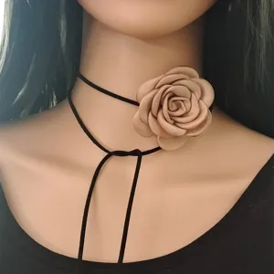 Primo piano dettaglio dell'elegante collana choker in tessuto con rosa e cordino.