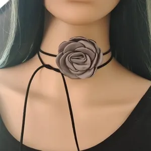 Primo piano dettagliato dell'elegante girocollo con fiore di rosa in tessuto grigio e laccio nero.