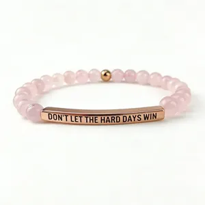 Vista dettagliata del braccialetto di perle in pietra rosa 6mm con citazione incisa.