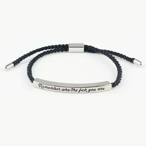 Vista dettagliata di un bracciale in corda intrecciata nera con barra metallica, regolabile.