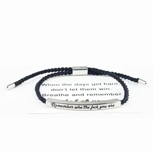 Bracciale in corda intrecciata nera con barra metallica incisa per accessorio di moda.