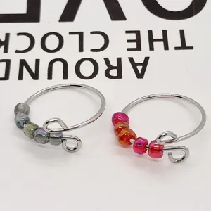 Anello antiansia in acciaio inossidabile con perle di vetro, primo piano del design.