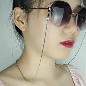 Gros plan détaillé d'une chaîne de lunettes en métal argenté élégante portée avec soleil.