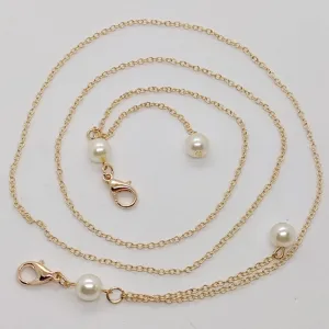 Goudkleurige metalen ketting met parels en karabijnsluitingen, gedetailleerd overzicht accessoire.