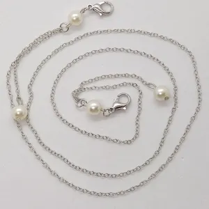 Gedetailleerd weergave van de zilveren ketting met parels en karabijnsluitingen voor brillen of maskers.