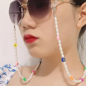 Gros plan de détail d'une chaîne de lunettes en perles colorées et fleurs souriantes portées.
