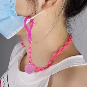 Pink acrylic smiley face mask chain detail shot, stylish neck lanyard accessory view.