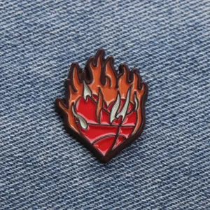 Close-up detail of a trendy flame basketball heart enamel pin, stylish metal badge for coats.
