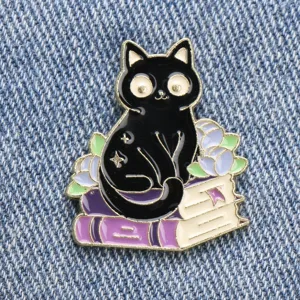 Close-up detail shot of the cute black cat and book enamel brooch pin with neat crafting.