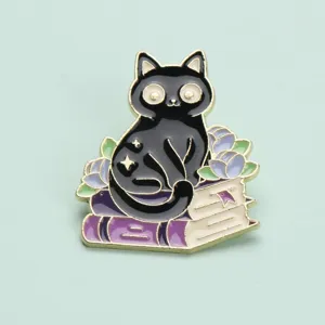 Exquisite enamel black cat and book brooch detail shot, stylish metal clothing accessory.