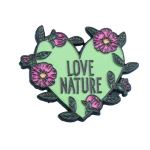Broche émaillée verte en forme de cœur avec des fleurs roses et texte pour vêtements.