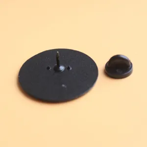 Detailansicht der schwarzen runden Brosche Rückseite mit sicherer Nadel und Gummi Verschluss.
