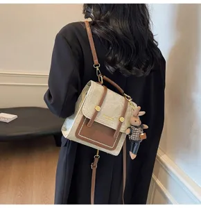 Retro college style small backpack in beige and brown with a cute rabbit keychain.