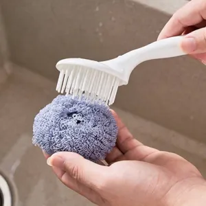 Ergonomische Küchenreinigungsbürste mit Griff und lila Nanofaserball über Spüle