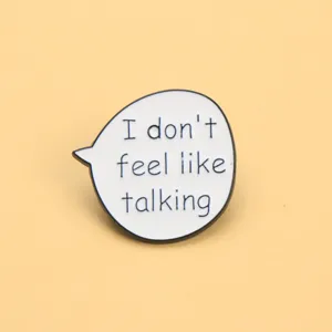 Detailed close-up of a funny English quote speech bubble enamel pin, perfect for clothing bags decoration.