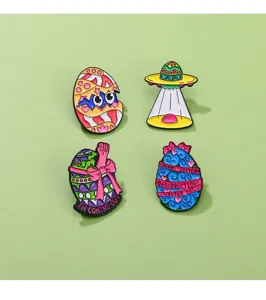 Close-up detail of creative Easter theme enamel pins set featuring cute cracked eggs and UFO.