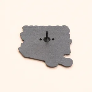 Detail van de achterkant van een zwarte metalen speld met veilige sluiting en pin.