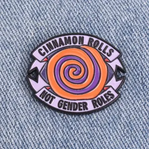 Close-up detail of the creative enamel metal brooch pin featuring slogan text and spiral design.