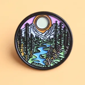 Round landscape enamel pin badge, mountain and river design, decorative brooch for clothes and bags.