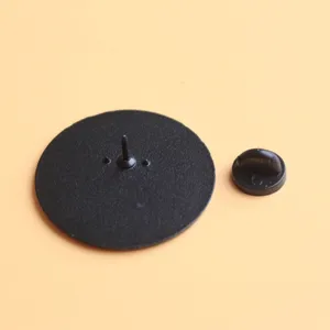 Detail view of the back of a black round enamel pin with a secure rubber clutch fastener.