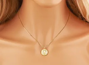 Detail shot of a gold plated little girl pendant necklace with white mother of pearl.