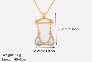 Détail en gros plan du collier pendentif cintre de bikini plaqué or avec des pierres de zircone.