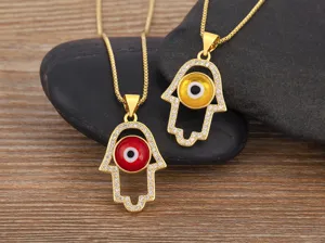Close-up detail of 18k gold plated Hamsa hand evil eye necklace with glittering cubic zirconia.