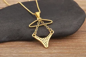 Gros plan de détail du collier pendentif bikini et cintre doré avec de jolies pierres de zircon.
