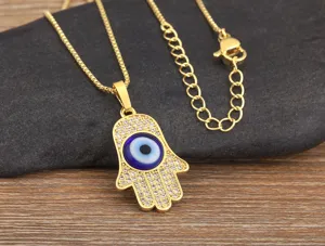 Gold plated Hamsa hand evil eye pendant necklace detail view showcasing zirconia stones.