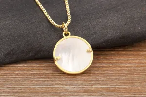 Gold plated white shell round pendant necklace detail close-up view, elegant daily jewelry.