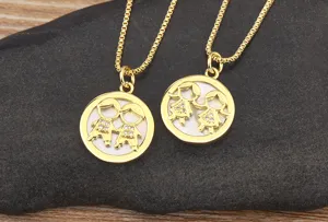 Close-up detail of gold plated boy and girl pendant necklace with mother of pearl and zircon.