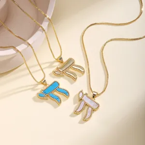Detailed shot of Hebrew Chai symbol necklaces with mother-of-pearl pendants and gold beaded chains.