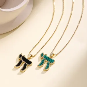 Close-up detail of Hebrew Chai symbol necklaces with black and malachite green curved pendants.
