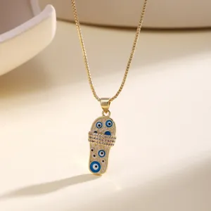 Χρυσό κολιέ με μινιατούρα μενταγιόν παντόφλας, μάτι και λαμπερά στρας σε λεπτομερή σχεδίαση.