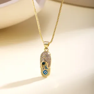 Detail shot of gold evil eye slipper necklace pendant sparkling pavé stones luxury style