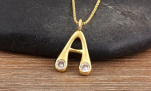 Gold plated letter A pendant necklace with sparkling zirconia stones close up detail view.