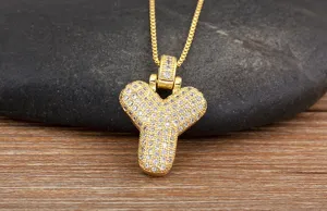 Gros plan détaillé d'un collier pendentif lettre Y plaqué or avec des zircons brillants.
