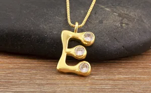 Detailed view of gold plated letter E pendant necklace micro-paved sparkling cubic zirconia.