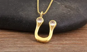 Gold-plated U-shaped pendant necklace detail featuring sparkling micro-inlaid clear zirconia.