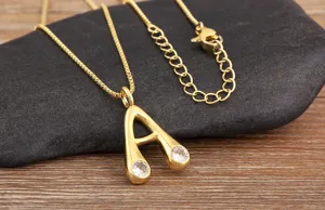 Close-up of gold-plated alphabet pendant necklace with sparkling cubic zirconia stones.