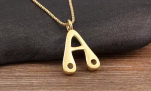 Closeup shot of a minimalist gold letter A pendant necklace resting on textured background.