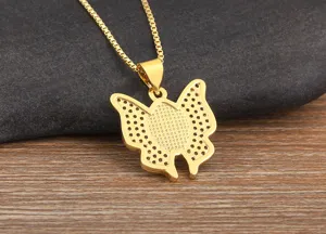 Gold plated butterfly pendant necklace with micro-pave details on wooden background detail shot