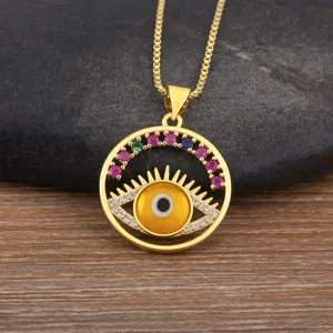 Dettaglio in primo piano della collana con ciondolo malocchio placcato oro con zirconi colorati.