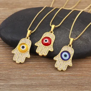 Gold plated Hamsa hand evil eye pendant necklace with sparkling cubic zirconia stones.