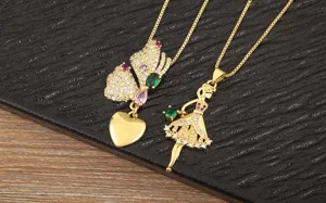 Vue detaillee de colliers en cuivre plaque or avec pendentif papillon et danseuse de ballet.
